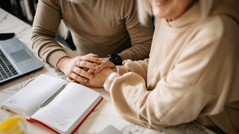 image shows couple holding hands with documents