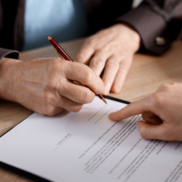 Image Shows: signing document w lawyer present