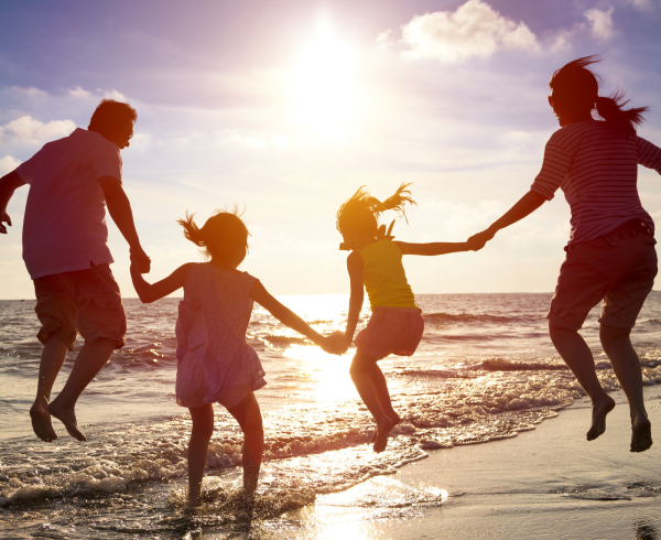 Image Shows: family jumping at the beach