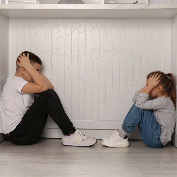 Image Shows: children hiding with hands on their head