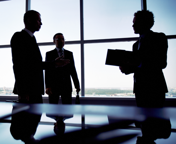 Image Shows: silhouette of people talking in meeting