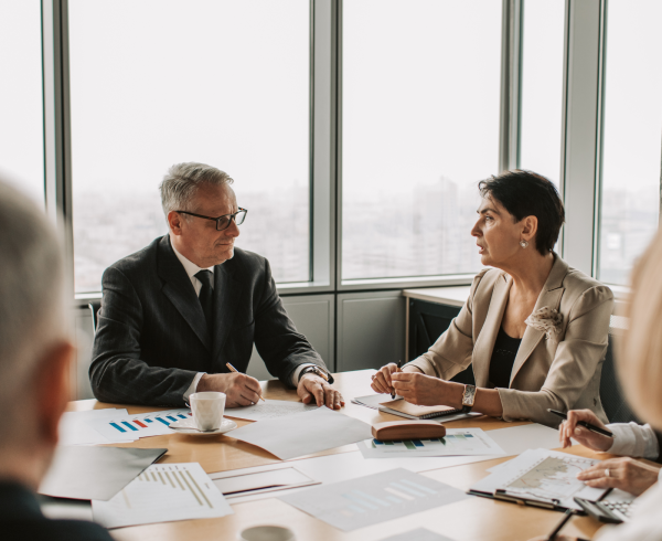 Image Shows: office workers in a meeting talking