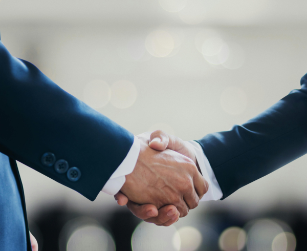 Image Shows: two people shaking hands in a suit