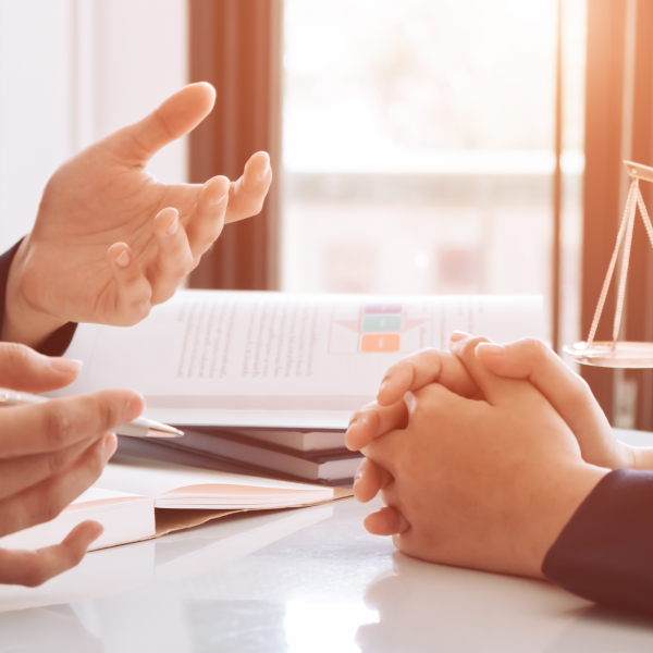 Image Shows: hands at a table showing two people discussing a matter