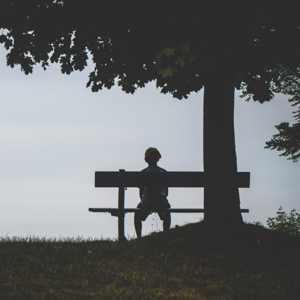 Image Shows: child sitting alone on bench