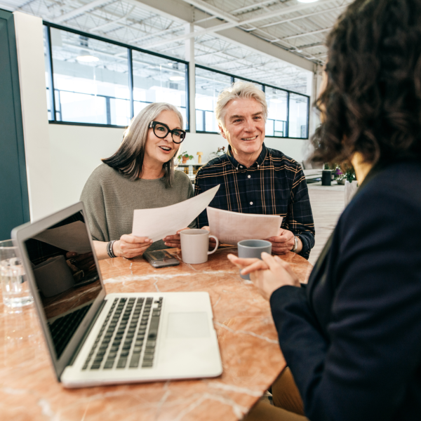 Image Shows: couple talking to a professional whilst holding documents