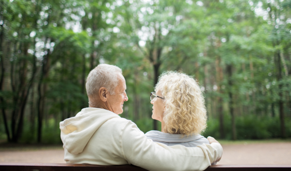 image shows couple sitting together on a bench outdoors