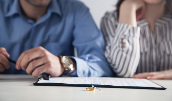 image shows: man and woman getting divorced as rings are place on the table
